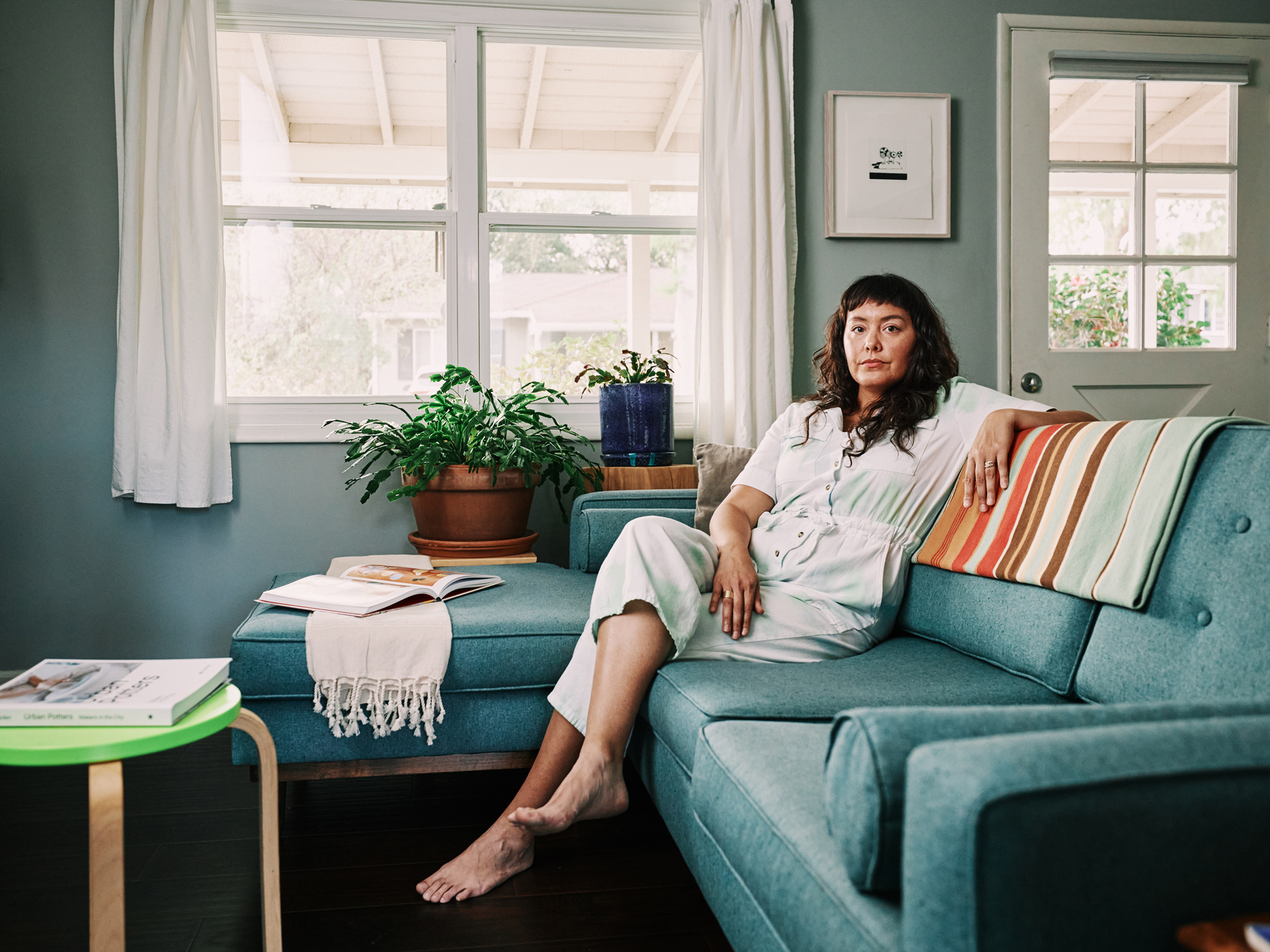 Angela Chvarak sitting on the couch in her living room.