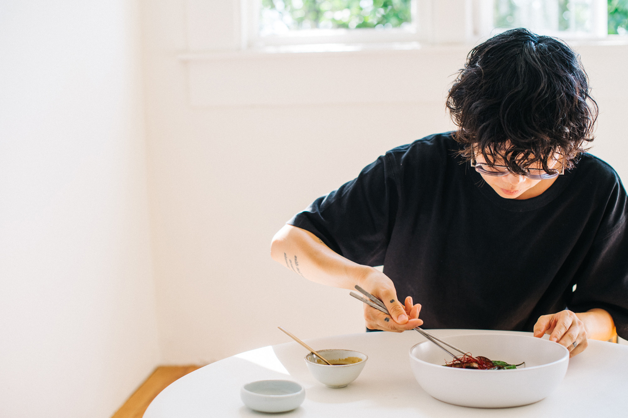 Michelle Jane Lee plating food at her kitchen table.