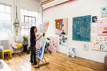 Ashley Mary painting on canvas in her studio.